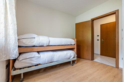 a room with three bunk beds and a door at Casa Valentina in Ledro