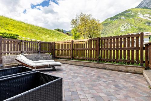 a patio with a white bench and a fence at Casa Valentina in Ledro
