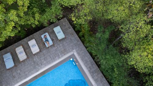 an overhead view of a pool with two people standing next to it at Saj In The Forest, Pench in Seonī