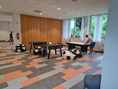 a group of people playing ping pong in a room at Remisens Hotel Albatros-All inclusive in Cavtat