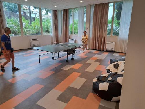 two people standing in a room with a ping pong table at Remisens Hotel Albatros-All inclusive in Cavtat