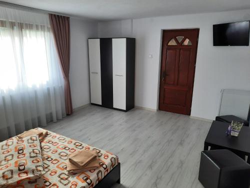 a small room with a bed and a door at Case de vacanță Gabriel in Sovata