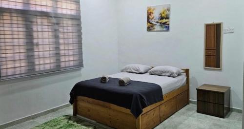 a bedroom with a bed with two shoes on it at Beril Homestay Full Aircond, Free Wifi, Netflix, Water Filter in Paka