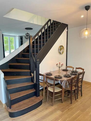 une salle à manger avec une table et un escalier dans l'établissement Le Guiton - Maison avec terrasse, à La Rochelle
