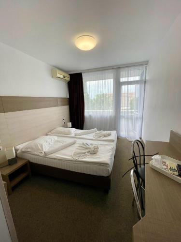 a bedroom with a large bed with a window at Hotel Aurora in Mamaia