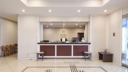 a lobby with a counter and stools in a room at Vessel Hotel Miyakonojo in Miyakonozyō
