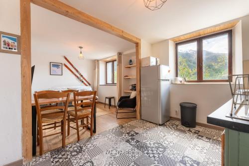 Il comprend une cuisine et une salle à manger avec un réfrigérateur et une table. dans l'établissement Gîte pour 20 personnes, Les Orres, aux Orres