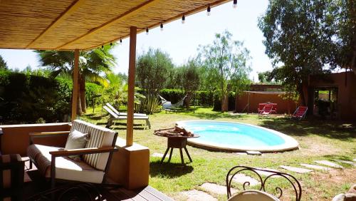 een achtertuin met een zwembad en een tafel en stoelen bij maison de campagne avec piscine in Marrakesh