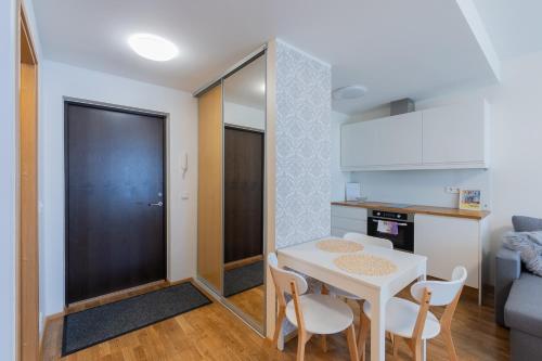 a small kitchen and dining room with a white table and chairs at Aida City Center Apartment in Pärnu