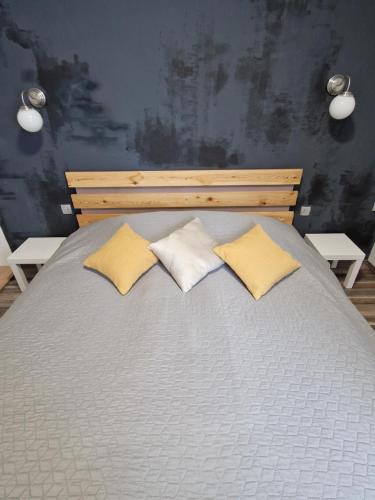 a large bed with two pillows on top of it at FRIZ&FANY Postojna City Center in Postojna