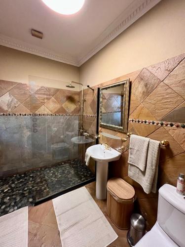 a bathroom with a shower and a sink at Forty 4 On Hoog in Polokwane