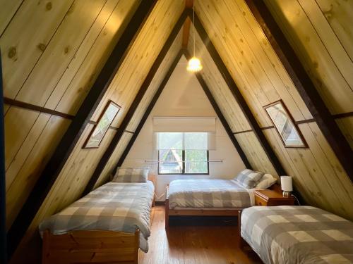 a attic room with two beds and a window at Grevillea at Porongurup Chalets in Porongurup