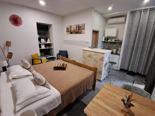 a bedroom with a bed and a table and a kitchen at Apartments Oaza in Split