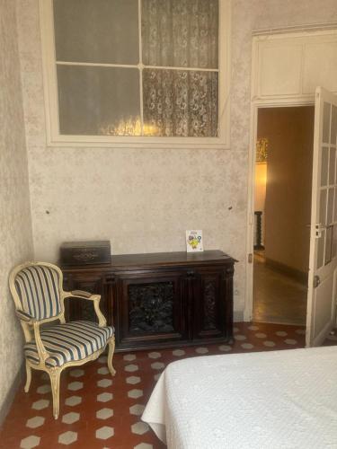 une chambre avec un lit, une chaise et une fenêtre dans l'établissement Appartement dans le Vieux-Nice, à Nice