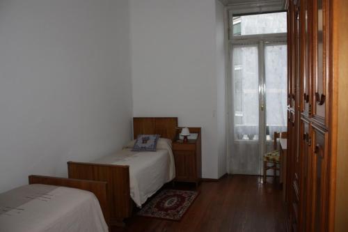 ein kleines Schlafzimmer mit 2 Betten und einem Fenster in der Unterkunft Affittacamere Stelvio in Sondrio