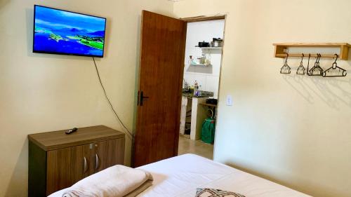 a bedroom with a television hanging on the wall at Morada Massala - Abraão - IG in Abraão
