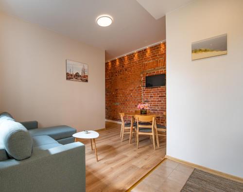 a living room with a couch and a brick wall at Red Brick Apartments in Klaipėda