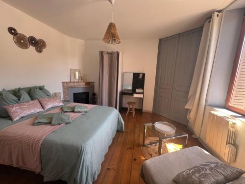 een slaapkamer met een bed, een bank en een tv bij Apartment La Viarhôna à Brégnier-Cordon in Brégnier-Cordon