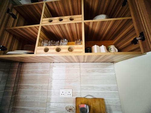 a small kitchen with wooden cabinets and a wall at Cottage chill in Kampala