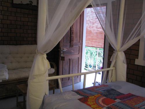 a bedroom with a bed and a window and a door at Avamada Lodge in Ivato