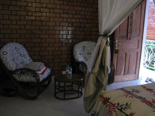 a bedroom with two chairs and a table and a door at Avamada Lodge in Ivato