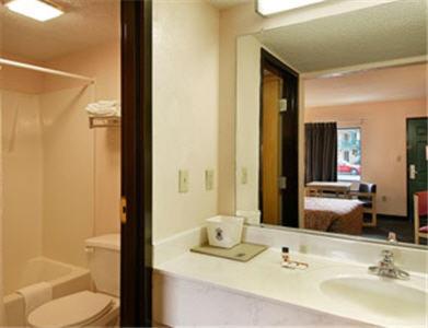 a bathroom with a sink and a toilet and a mirror at Super 8 by Wyndham Columbia in Columbia