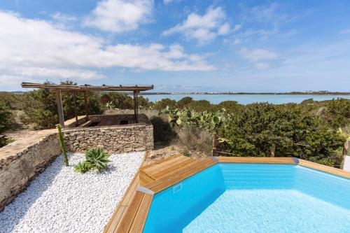 a swimming pool with a view of the water at Cas Saliners - Villa Can Paya in La Savina