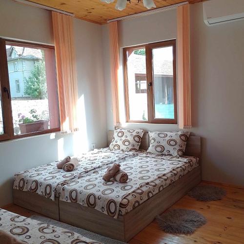a bedroom with a bed with two teddy bears on it at КРУШУНСКИ КЪТ ТЕЯ in Krushuna