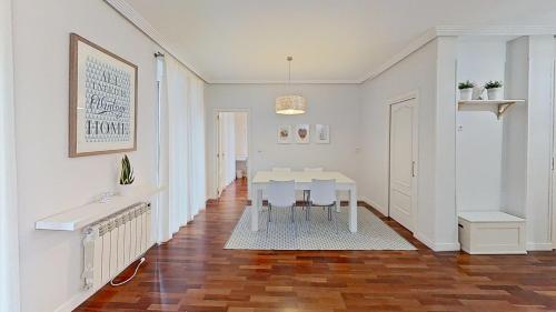 uma sala de jantar branca com uma mesa e um corredor em Always Easy I Escolta Real em San Sebastián