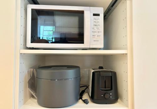 a microwave on a shelf with a toaster and a printer at まるしっぽ邸-Marushippotei-連泊20パーセントOFF!Onsen,BBQ,hammock,national park,home theater in Murautsuri