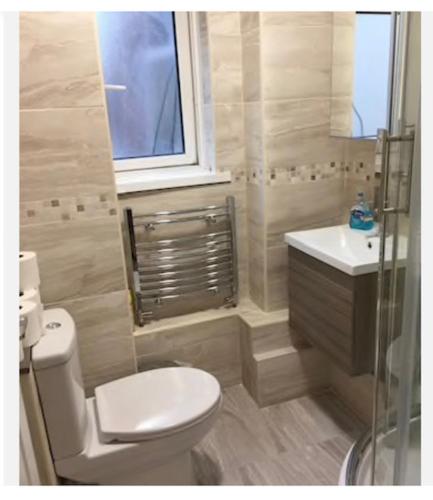 a bathroom with a toilet and a sink and a window at PRIVATE ROOM IN SIDMOUTH STREET, KINGS CROSS in London