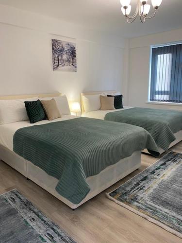 a bedroom with two beds and a chandelier at PRIVATE ROOM IN SIDMOUTH STREET, KINGS CROSS in London