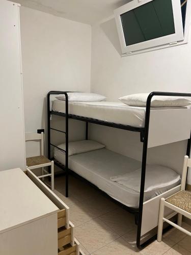 a room with two bunk beds and a flat screen tv at Monolocale La torre in Rio Marina