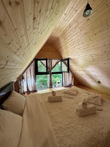een slaapkamer met een groot bed en handdoeken bij Chalet Rivier • შალე რივიერ in K'eda