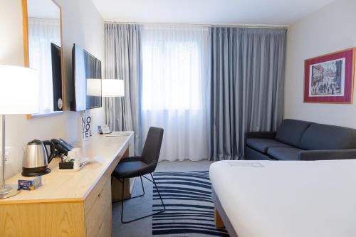 una camera d'albergo con letto e divano di Novotel Manchester West a Worsley