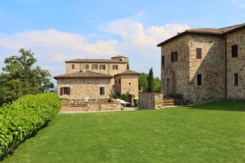 an old stone building with a green lawn at Castello di Viano in Viano