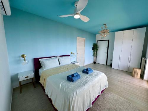 a bedroom with a large bed with a blue wall at Tropea Hills #5 in Santa Domenica