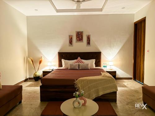 a bedroom with a large bed and a table at Guru Sadan A Luxe Stay in Ayodhya