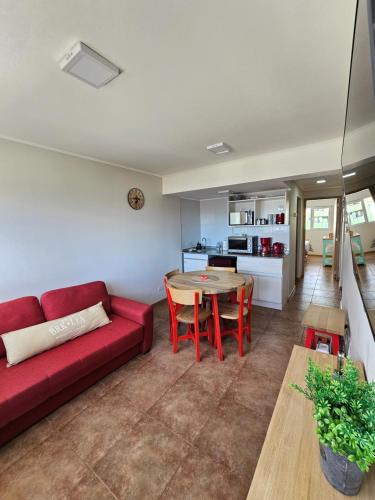 sala de estar con sofá rojo y mesa en Suite Vintage Bariloche en San Carlos de Bariloche