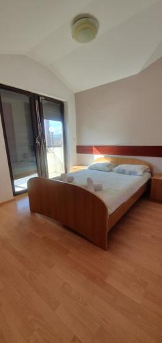 ein großes Bett in einem Zimmer mit Holzboden in der Unterkunft Ivanoski Studios and Guest Rooms in Ohrid