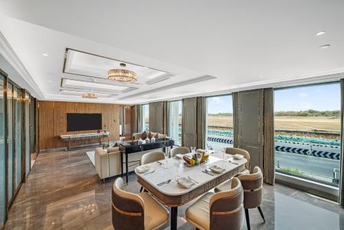 a room with a table and chairs and a television at Radisson Blu Hotel & Suites GRT Chennai in Chennai