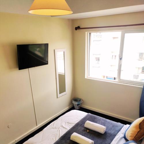a bedroom with a bed and a flat screen tv at Liberdade Home Royal direito in Braga