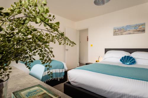 a bedroom with a bed and a potted plant at Quayside View - Luxury Apartment on Paignton Harbour in Paignton