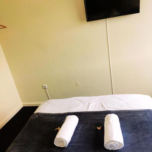 a bed with two rolls of paper towels on it at Liberdade Home Royal direito in Braga