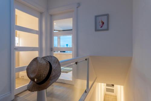 a hat is sitting on top of a staircase at Quayside View - Luxury Apartment on Paignton Harbour in Paignton