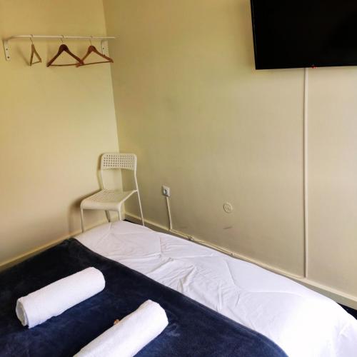 a room with a bed with a chair and a television at Liberdade Home Royal direito in Braga