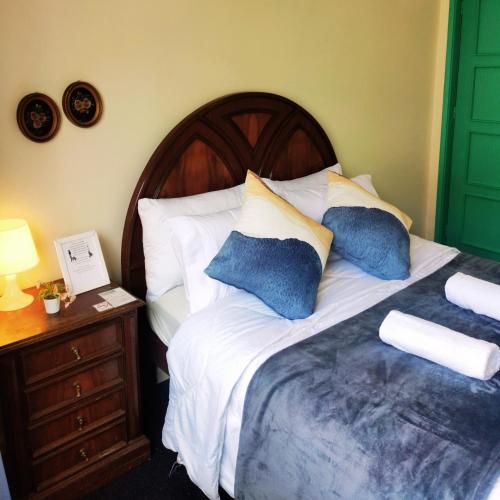 a bedroom with a bed with blue and white pillows at Liberdade Home Royal direito in Braga