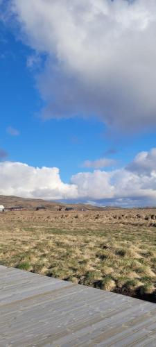 a path in a field with a blue sky at Cozy cottage, Mountain view in Selfoss