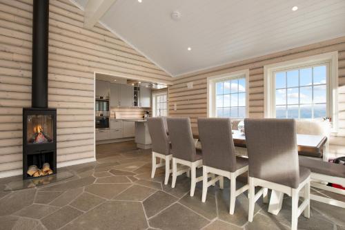 a dining room with a fireplace and a table and chairs at Voss Resort self-service apartments in Skulestadmo