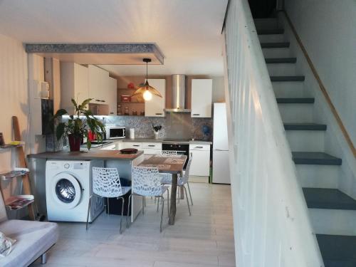 eine Küche mit einem Tisch und eine Küche mit einer Waschmaschine in der Unterkunft Maison entre lac et océan WIFI in Lacanau